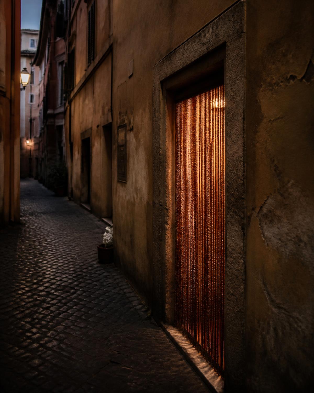 Unmarked Roman doorway with a glowing bead curtain at dusk